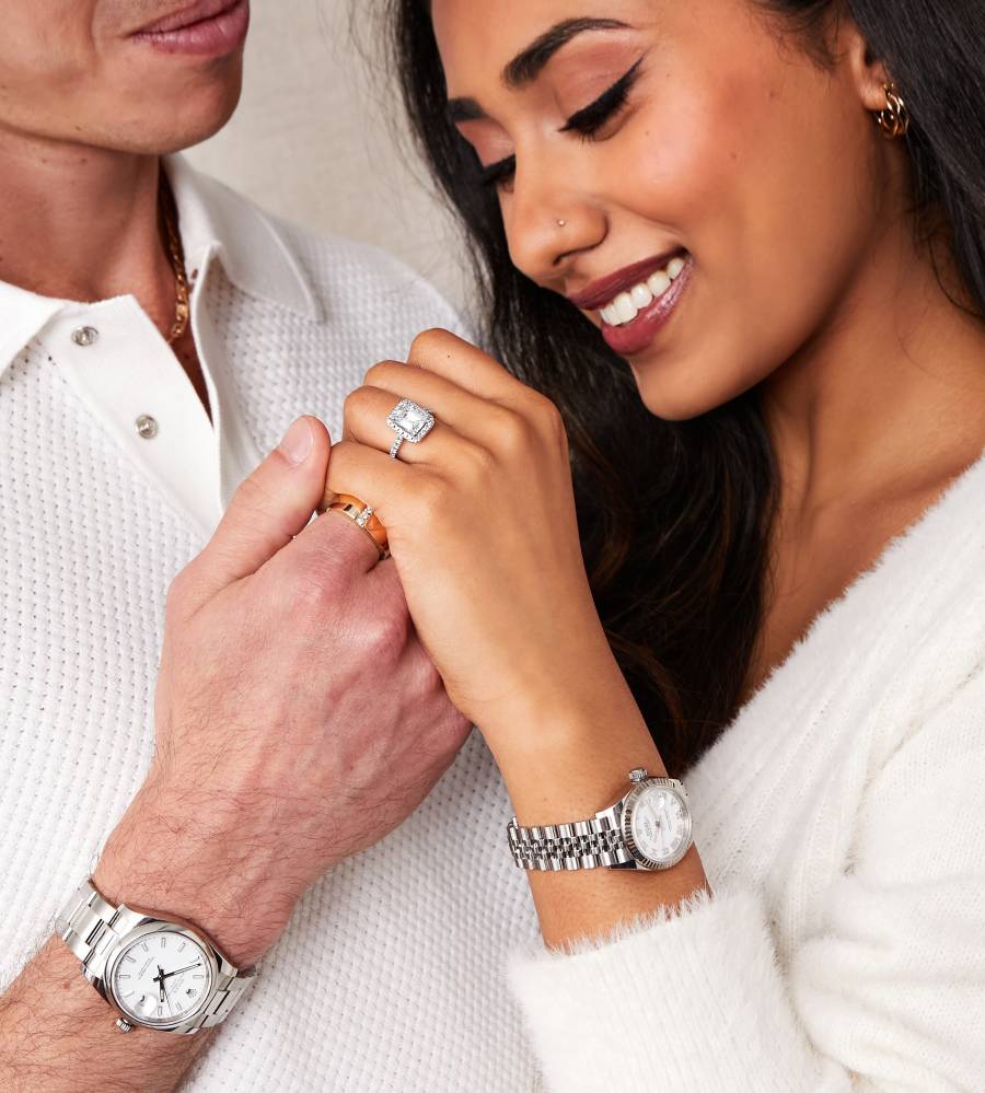 couple holding hands with engagement ring