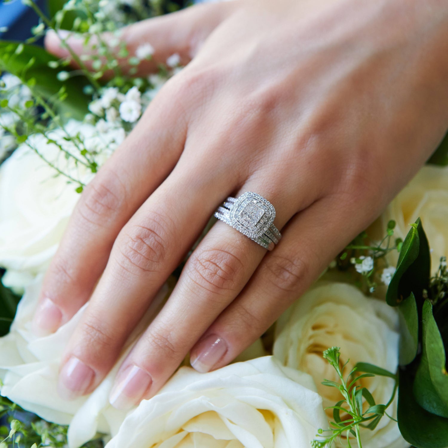 engagement ring on hand with bouquet