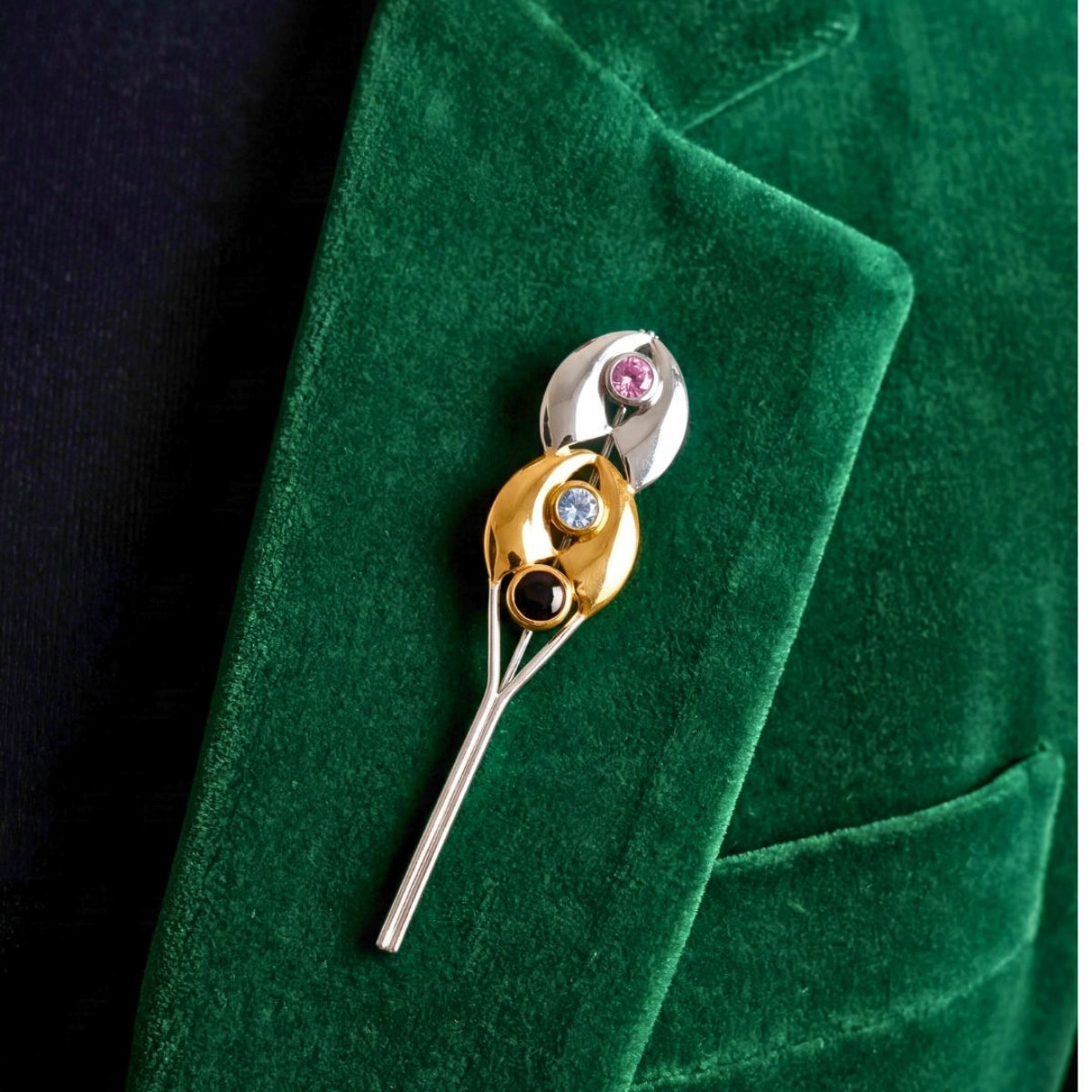 Pre-owned two-tone gold and silver gemstone brooch on green velvet blazer